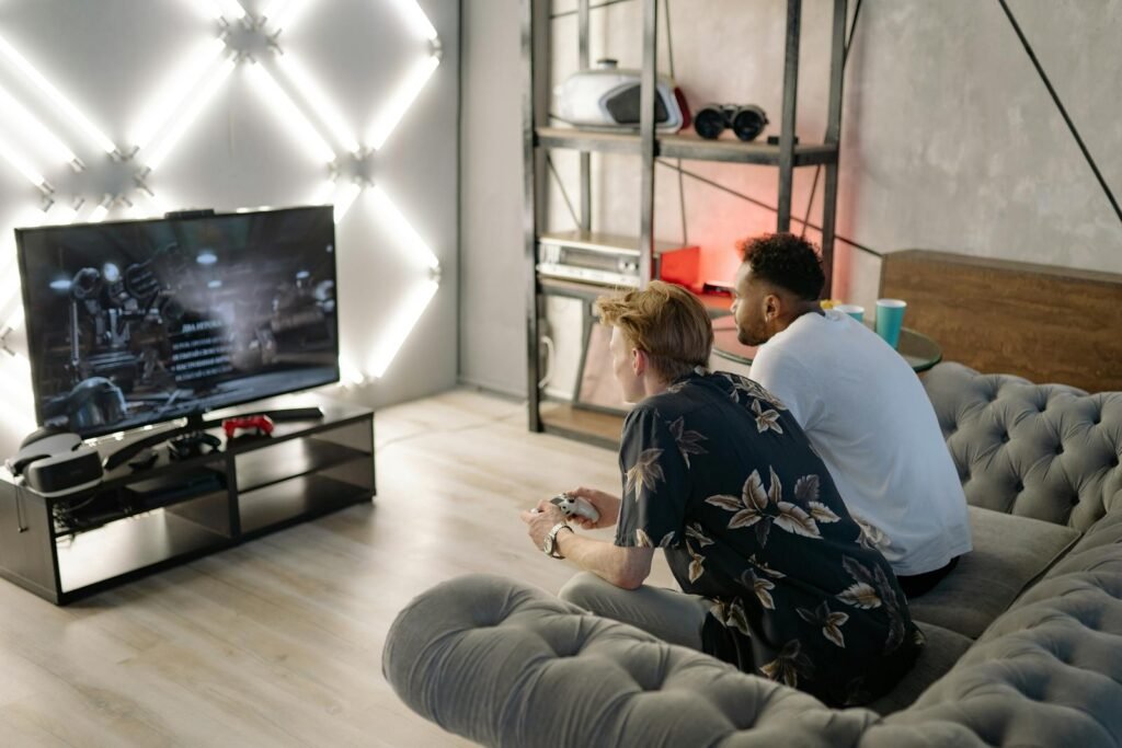 Two young men gaming together in a stylish modern living room with a large TV.
